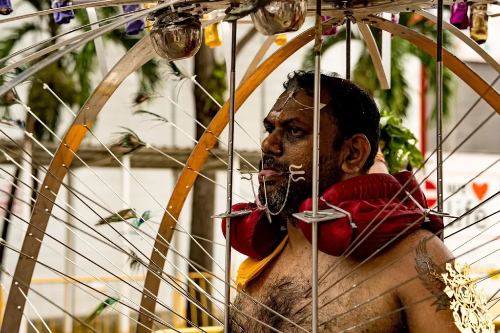 most unique festival - In the photograph, a sea of colorful devotees and pilgrims fills the streets, many dressed in bright traditional attire, adorned with intricate jewelry, flowers, and turmeric paint. The air is thick with incense smoke and the rhythmic beat of drums and chants, creating an atmosphere charged with reverence and energy.