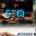 Person working on a laptop with the word "SEO" glowing above their hand, symbolizing search engine optimization.